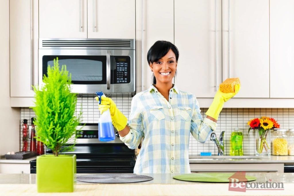 Young woman cleaning kitchen